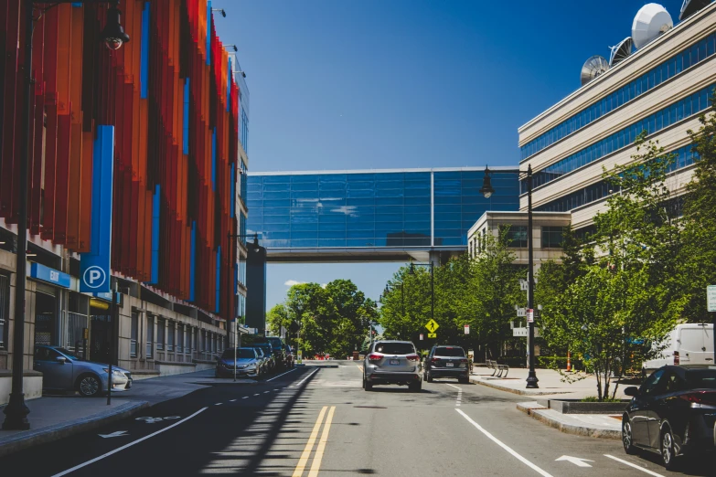 cars are driving down the street beside a building and bridge