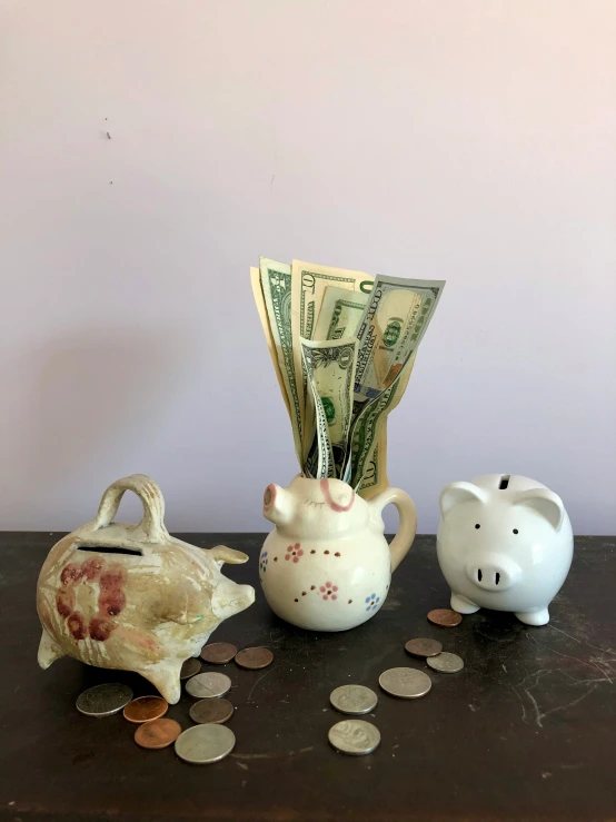 money is scattered around three white ceramic items