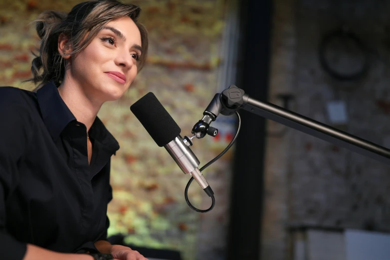 woman with dark hair holding microphone at indoor recording area