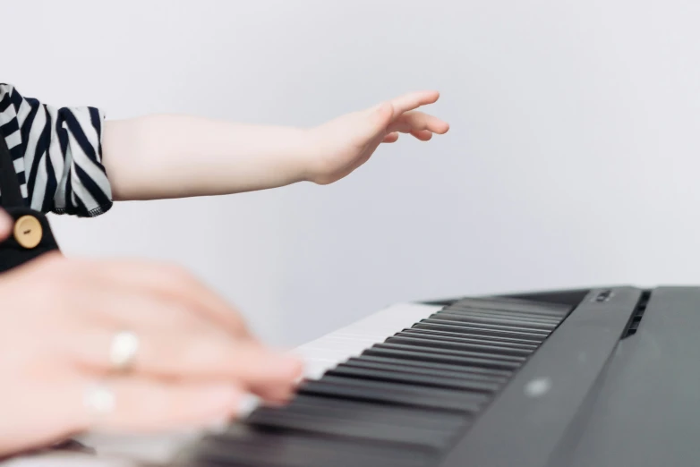 a person holding on to the piano keys