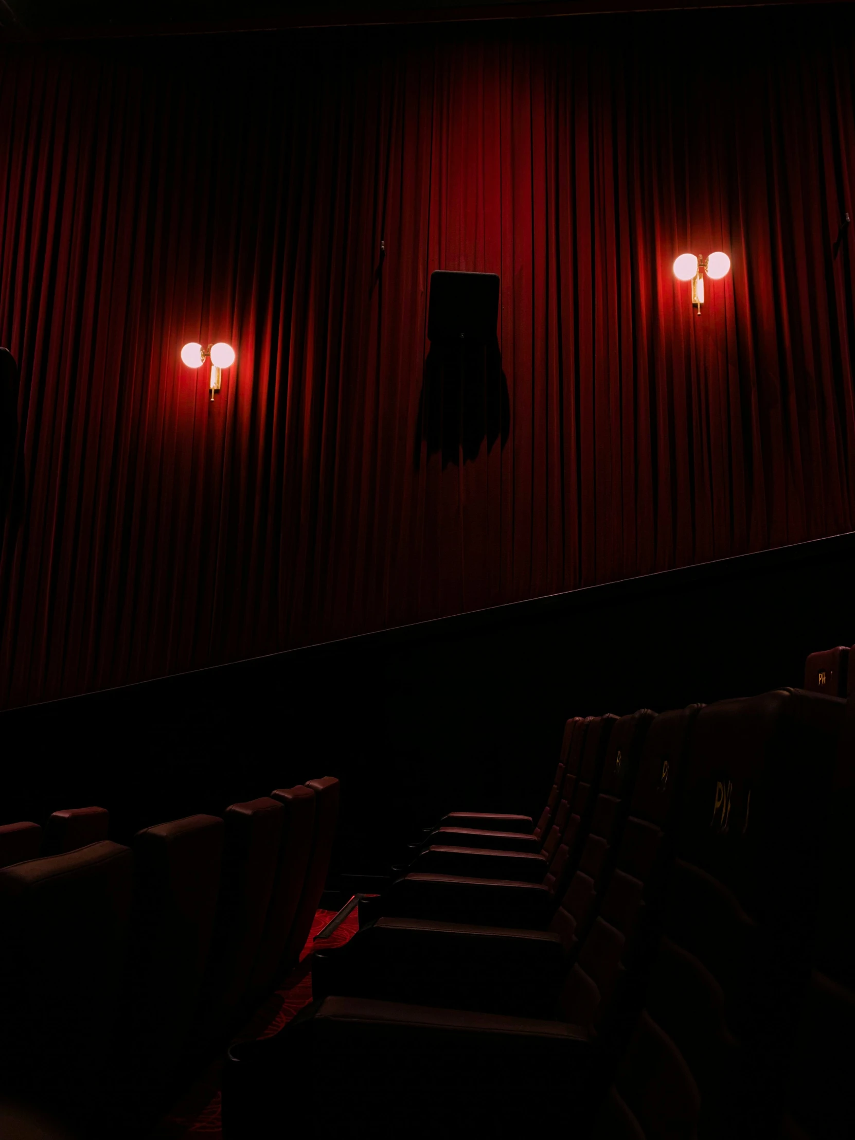 a theater that has red light shining in the dark