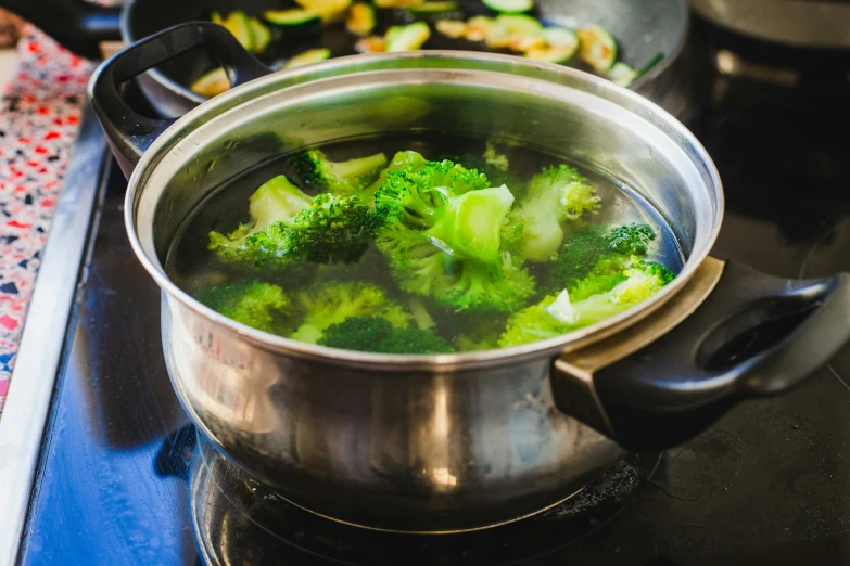 broccoli is boiling in a pot on a stove