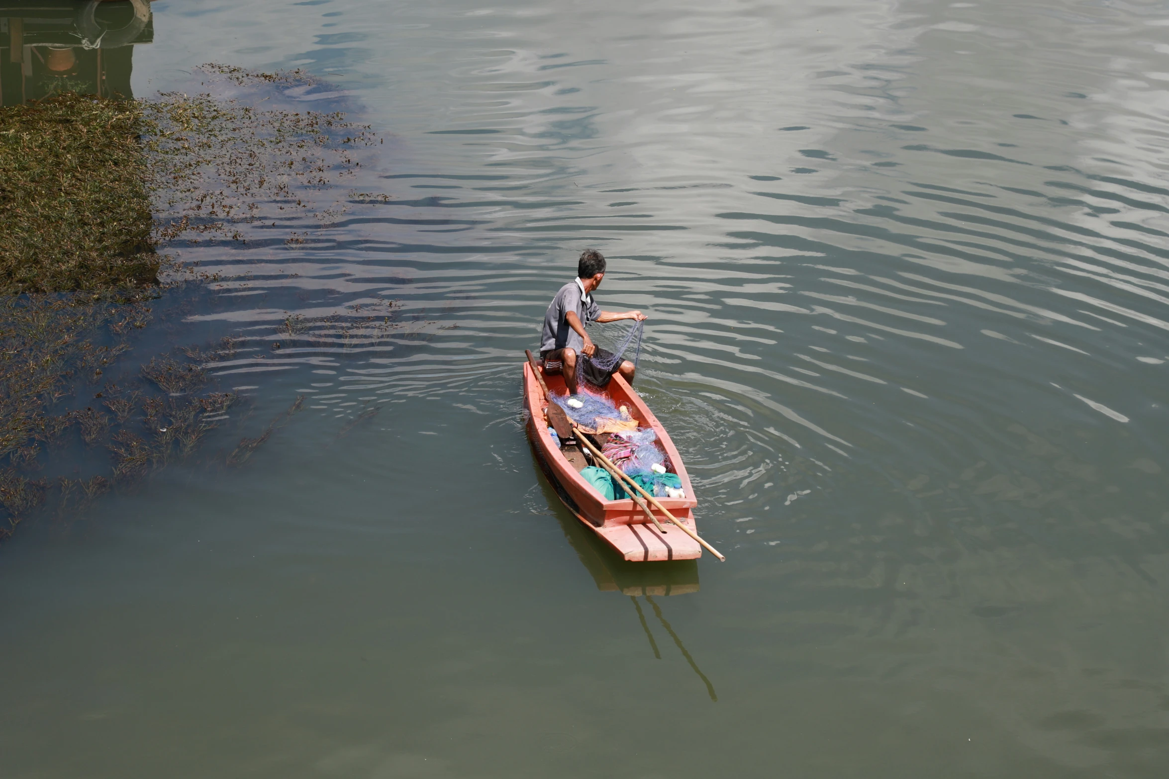 the person on the small red boat is going across water