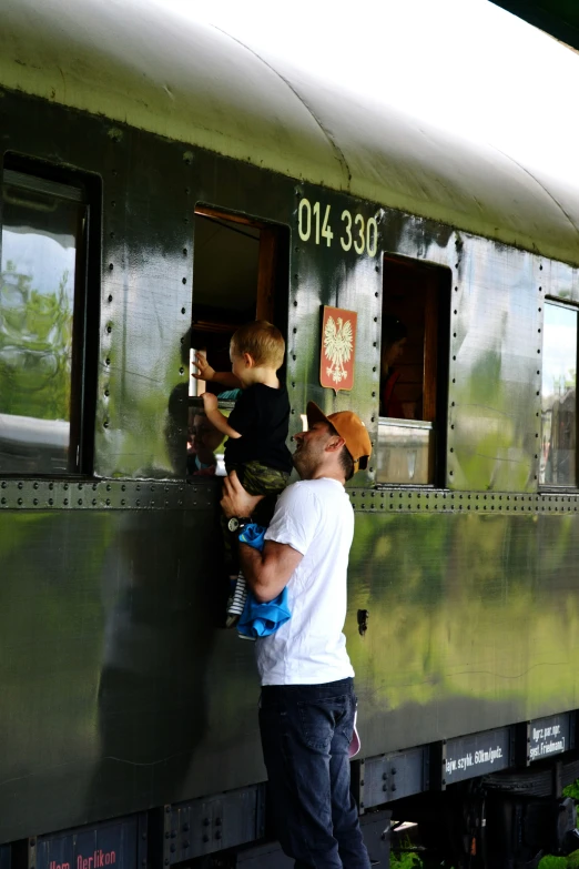 a man standing next to a child on a train