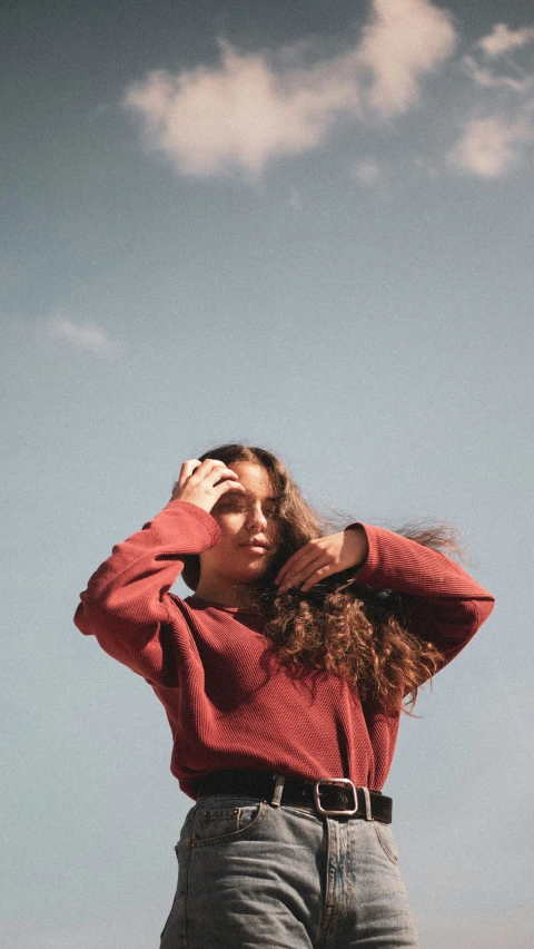 a young woman is standing outside against a blue sky