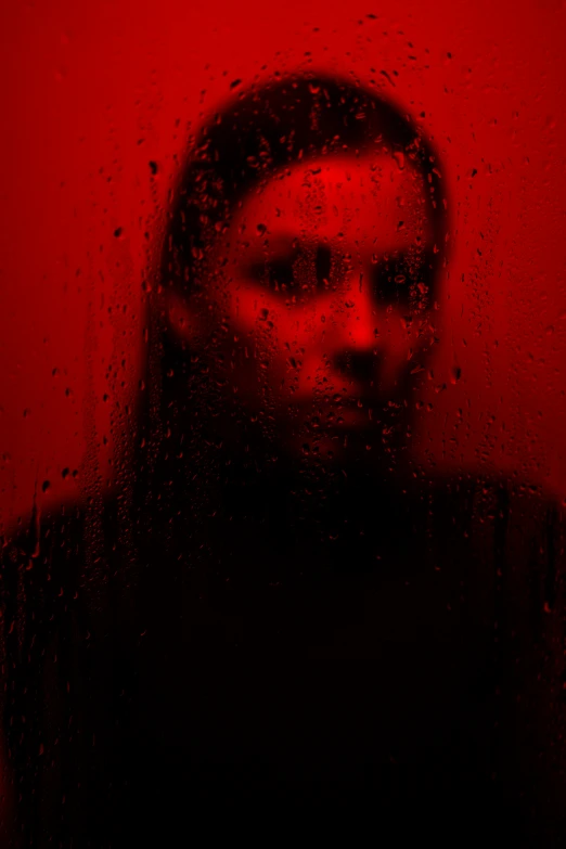 a woman standing in front of rain drops, in the red background