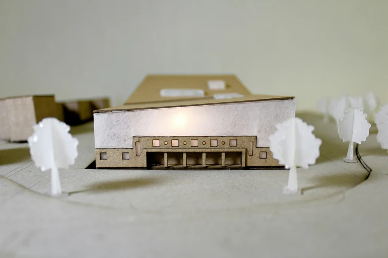 a model building is displayed with white trees in the foreground