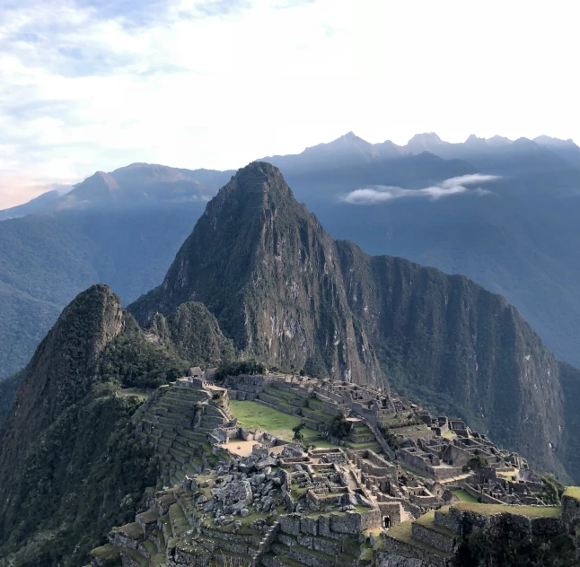 a man sitting at the top of a mountain watching mountains