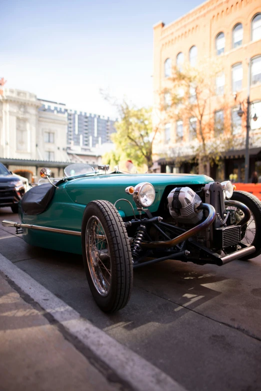 a green car driving down a road on top of street