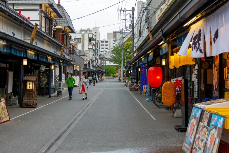 two people walking in an asian - style street area