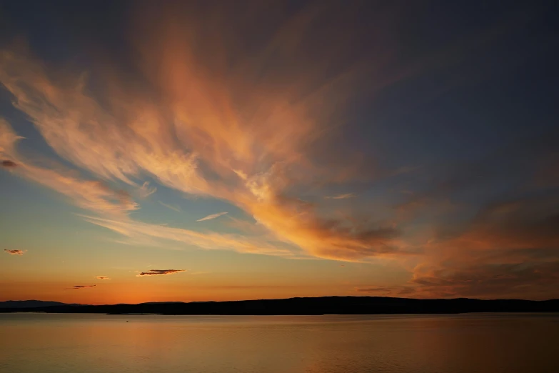 a beautiful sky over some water at sunset