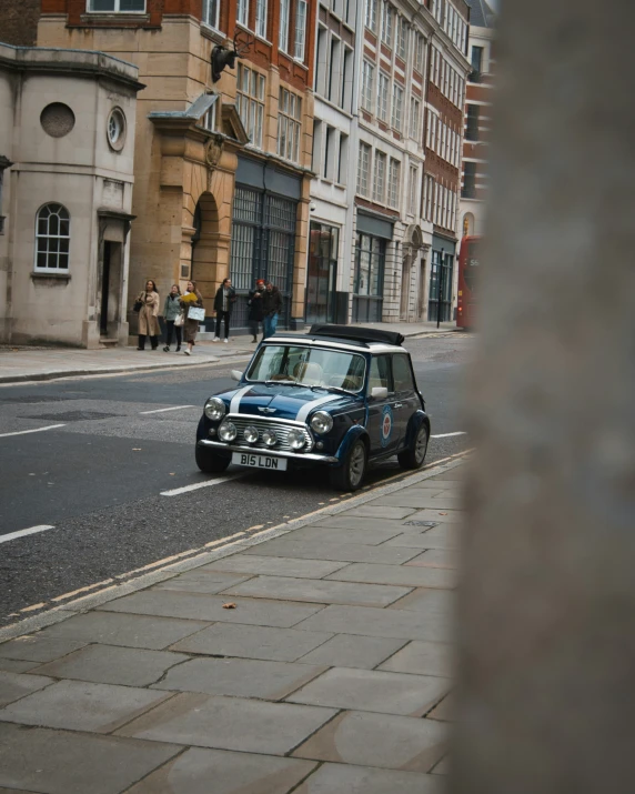 an old model car is parked on the sidewalk