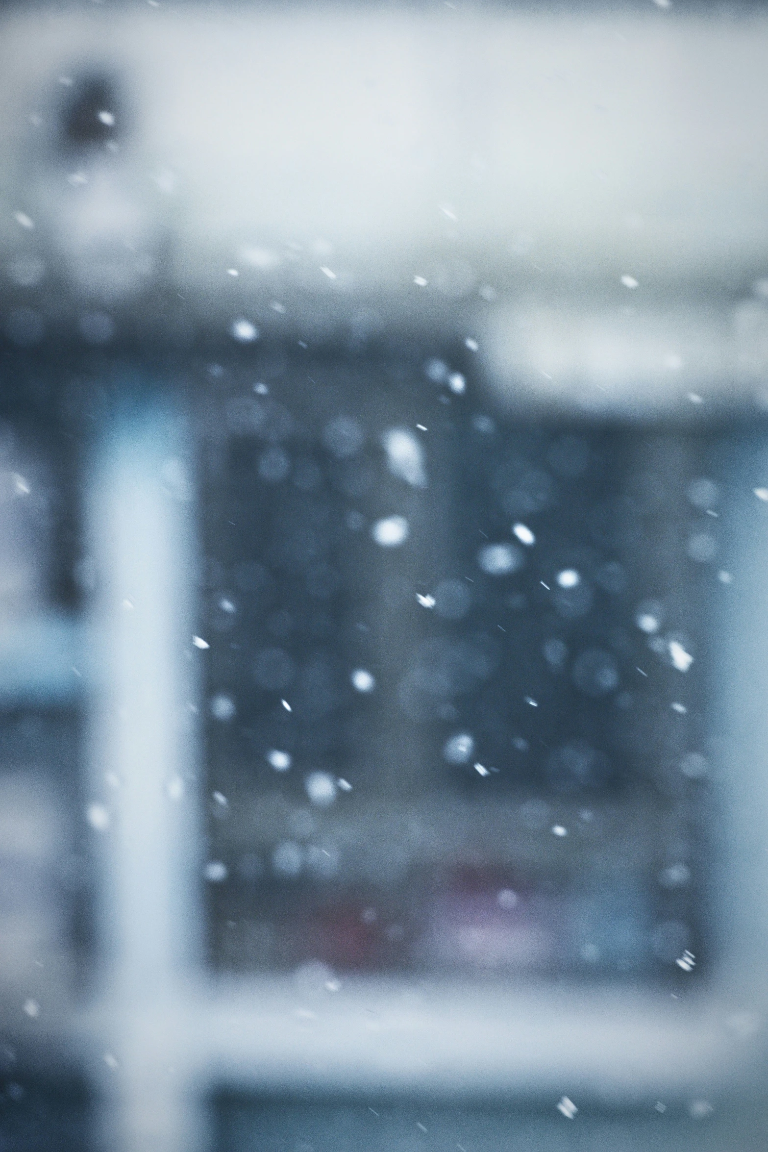 a snowy window with snow falling off of it