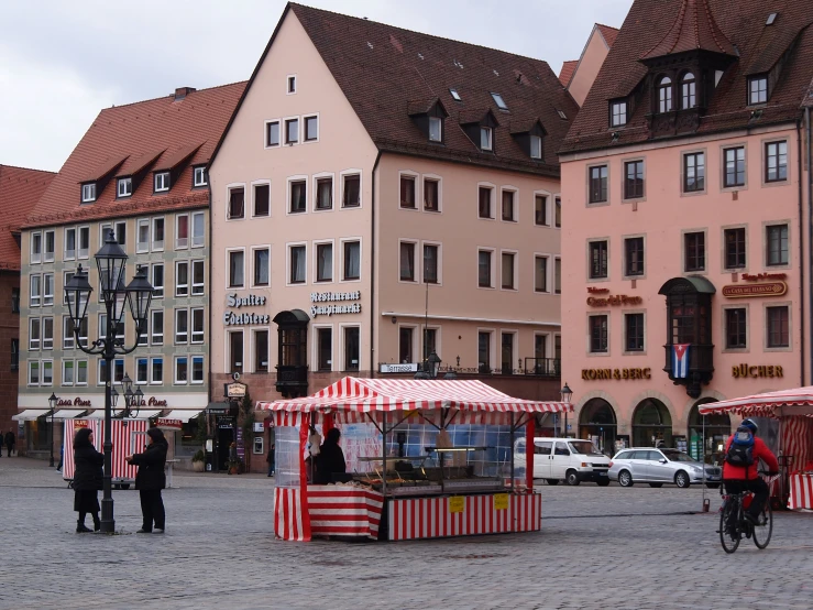 some people are walking on the street with buildings in the background