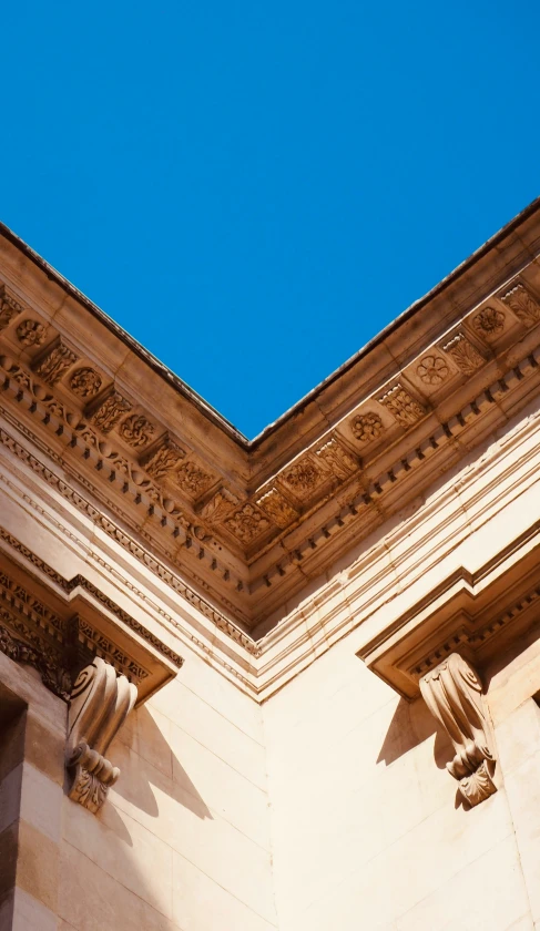 the corner of an intricate architectural structure against a blue sky