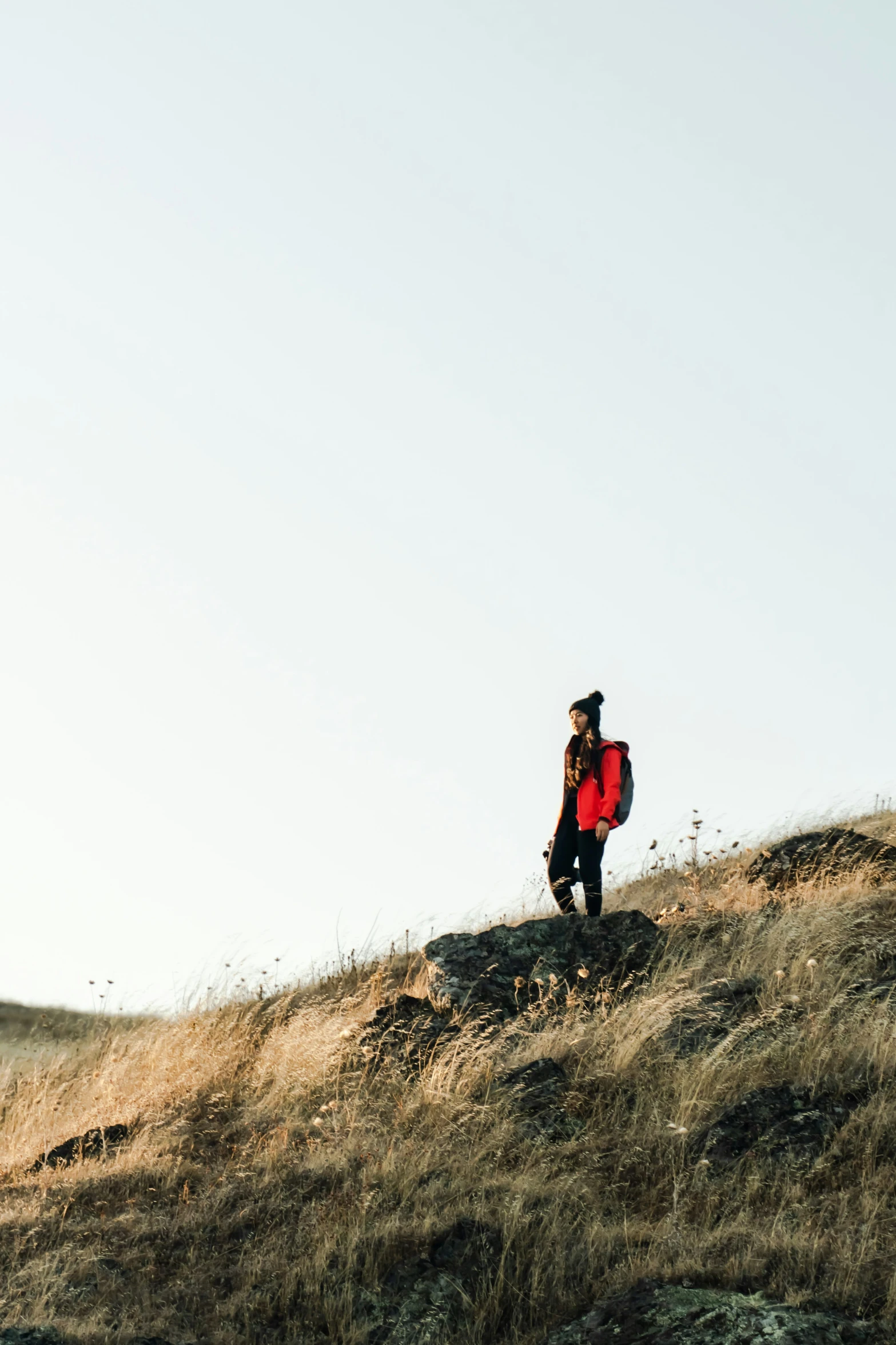 a man standing on a hill covered in grass