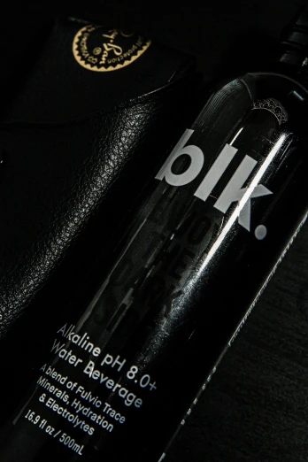 a bottle of vodka sits beside a black wallet