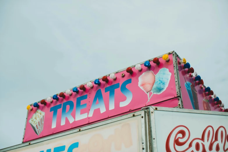 a pink food truck with a red sign for the store