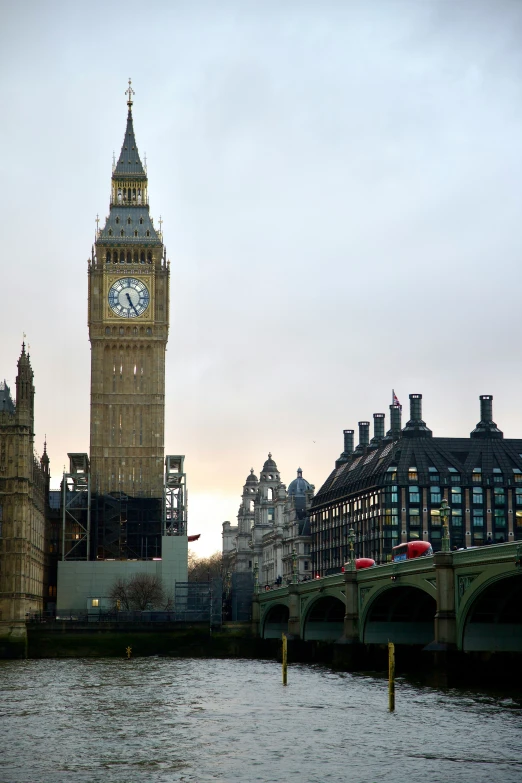 an old bridge runs across the river near big ben