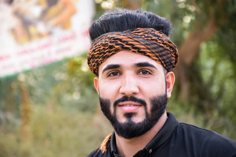 a man with a beard in a head tie posing for the camera