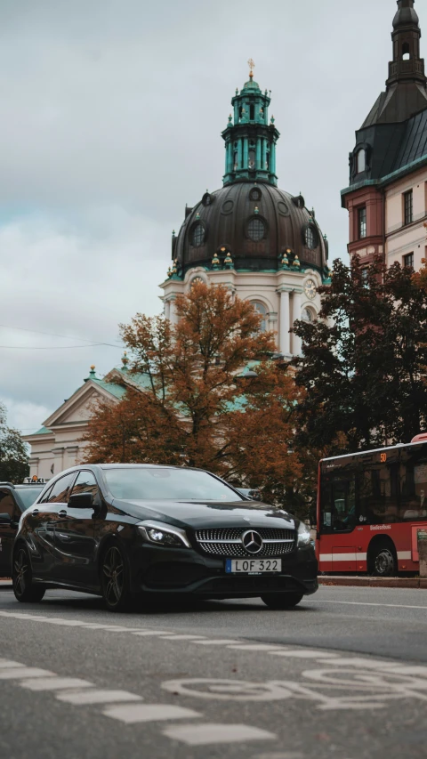 a black mercedes car driving down a street