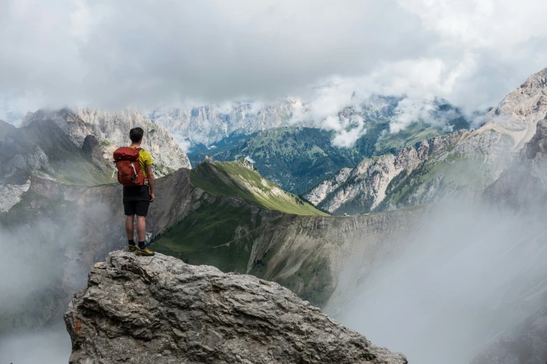 a hiker is on top of a mountain with a view of mountains