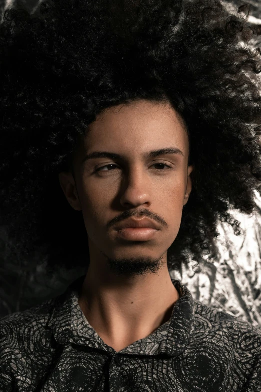 a man with a long, shiny afro with a moustache