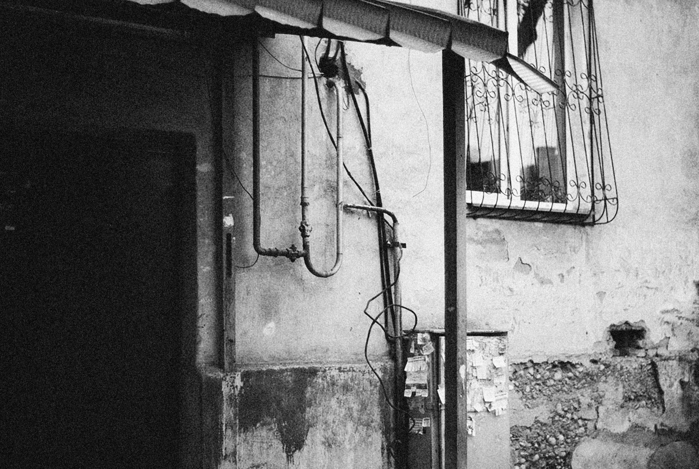 a door way to an old building with an iron bars on the window