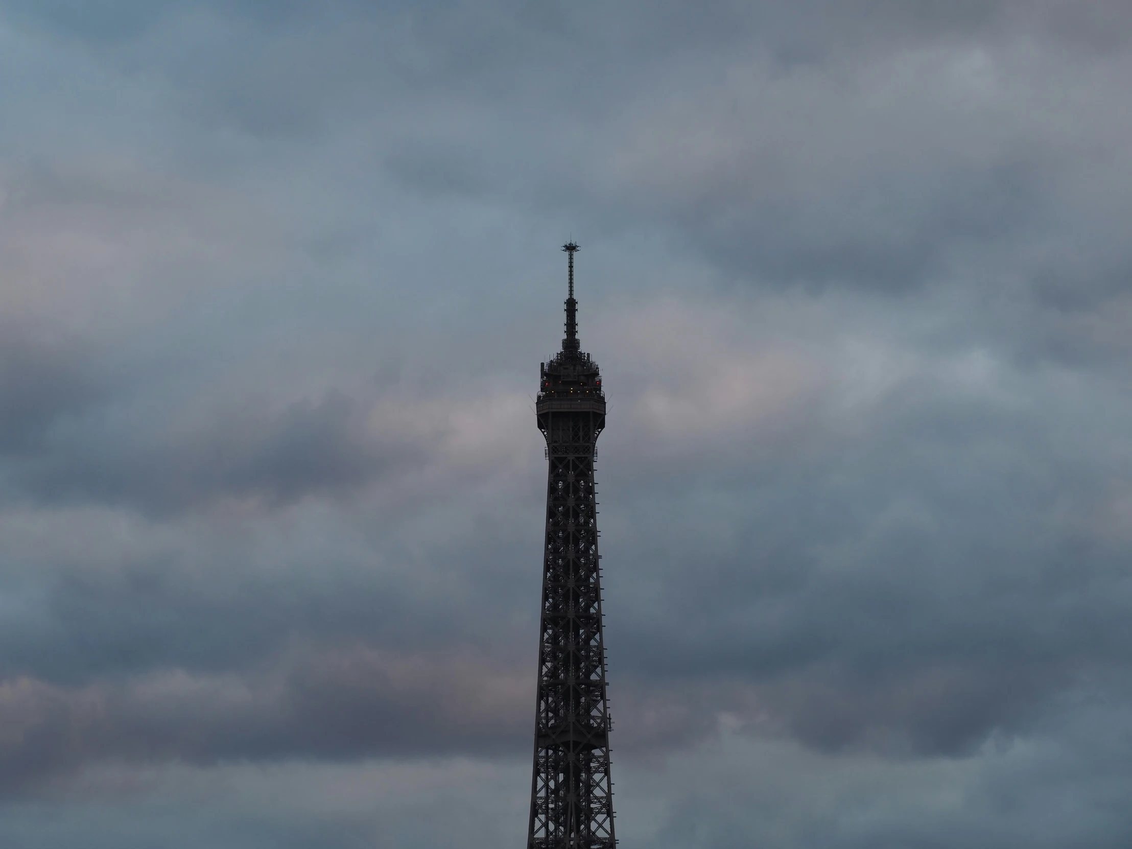 a large tower in the distance under some clouds