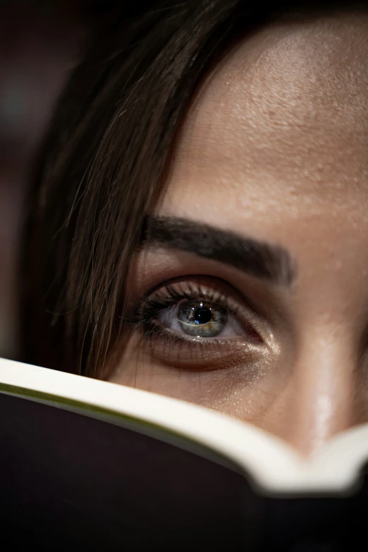 an eyes of a woman reading a book