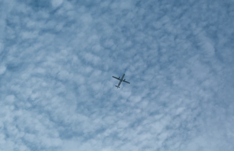 an airplane flying in the air on a cloudy day