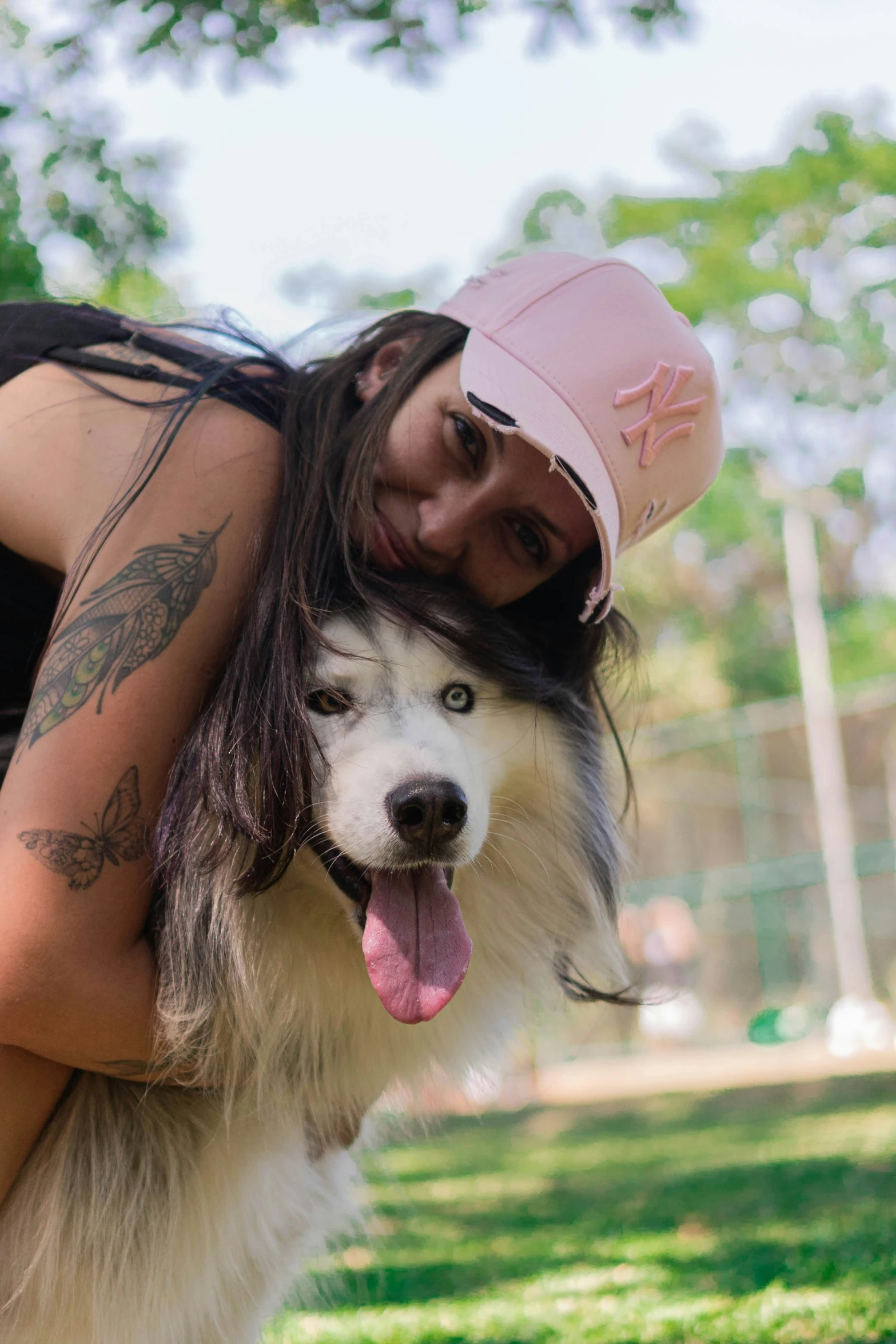 a beautiful woman hugging a large white and gray dog