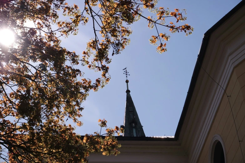 an old church has a steeple and is lit up by the sun