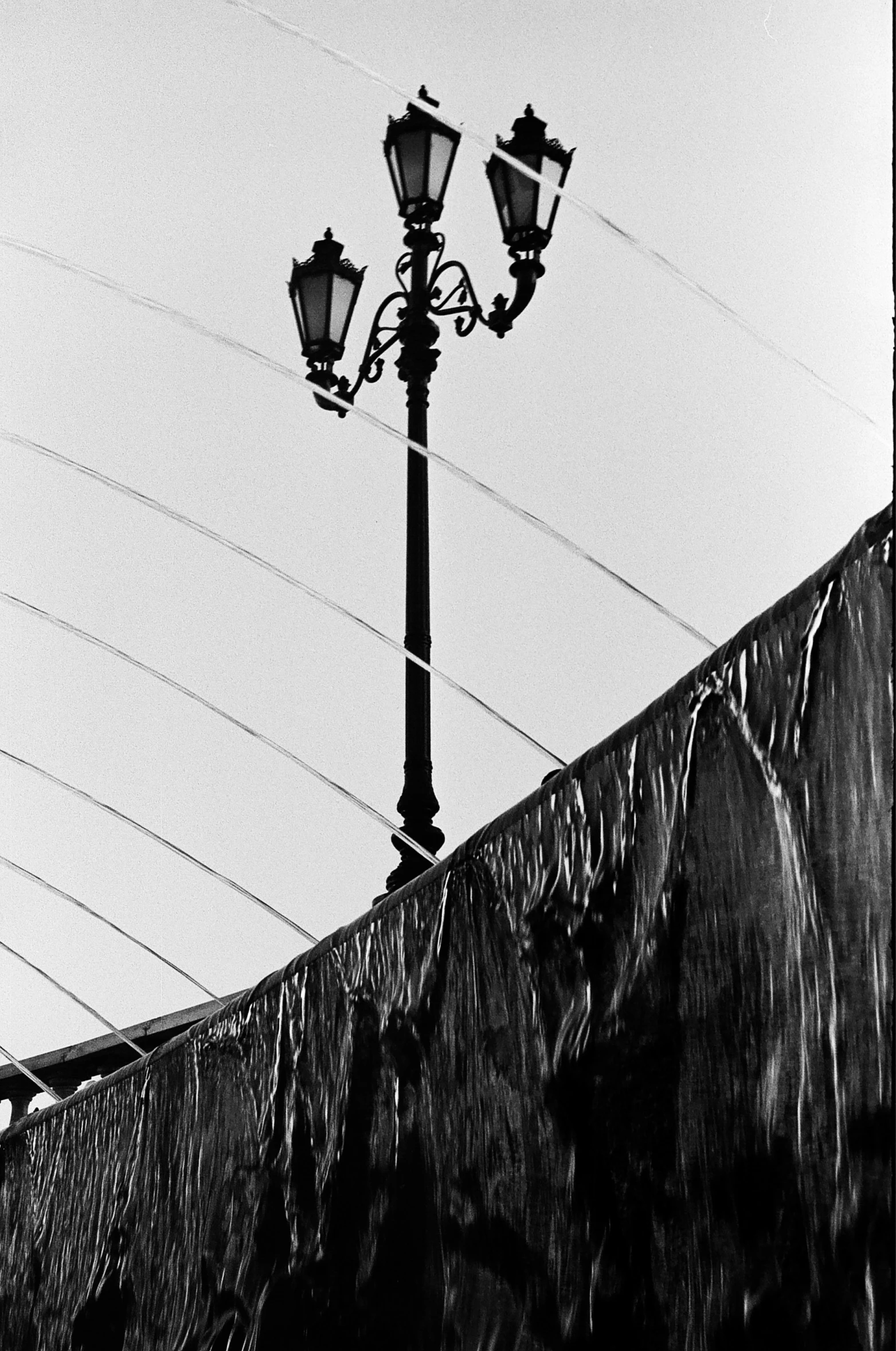 black and white pograph of two street lamps against an overhang