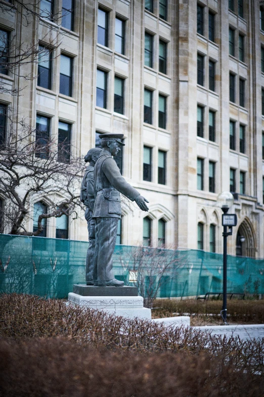 statue on the side of the street in front of a big building