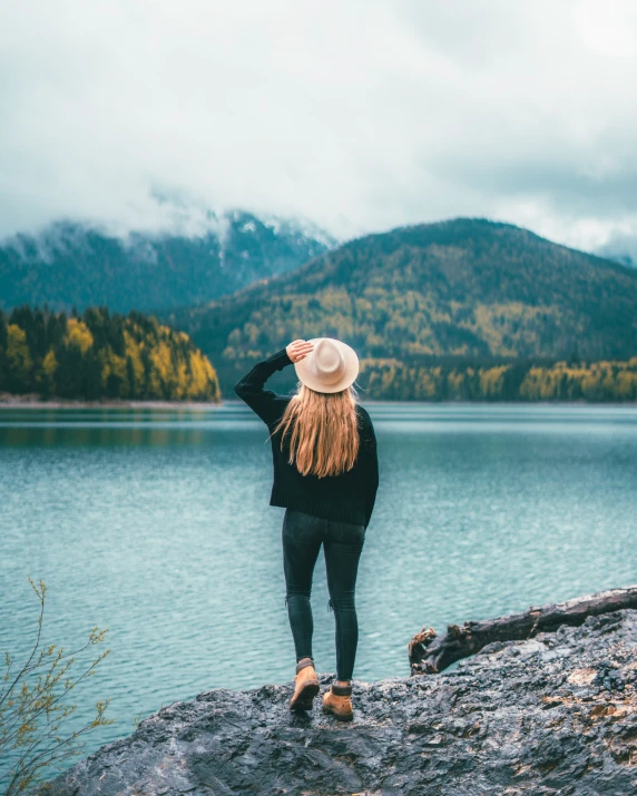 a woman stands near the edge of a body of water