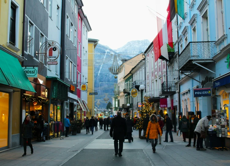 the people are walking down the sidewalk in the town