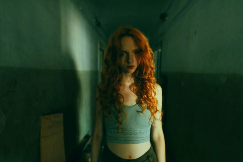 a woman with red hair is looking down while standing in an empty room