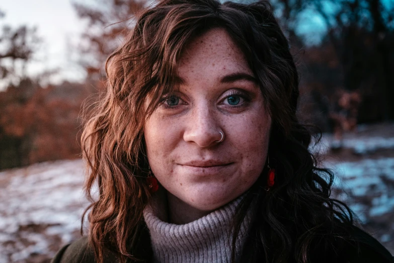 the woman with curly hair has an ear piercing