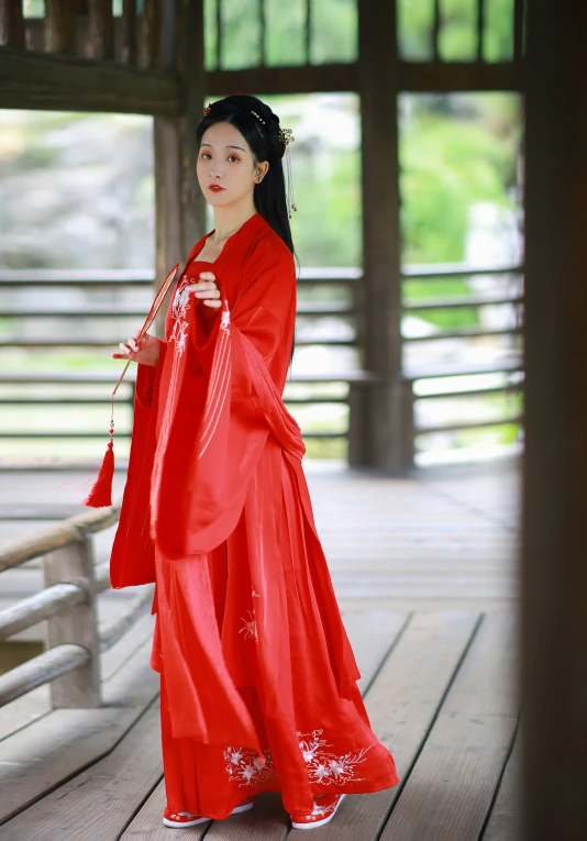 a woman in a chinese dress stands on the ground