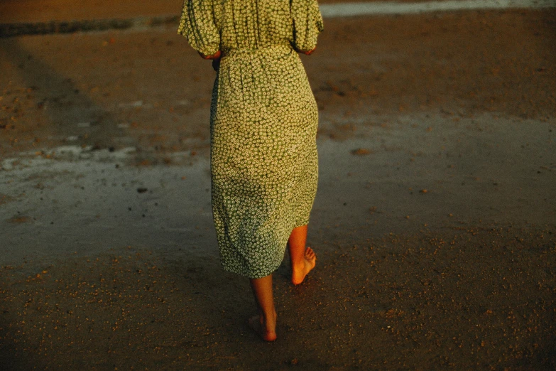 a woman walks on the street wearing a dress