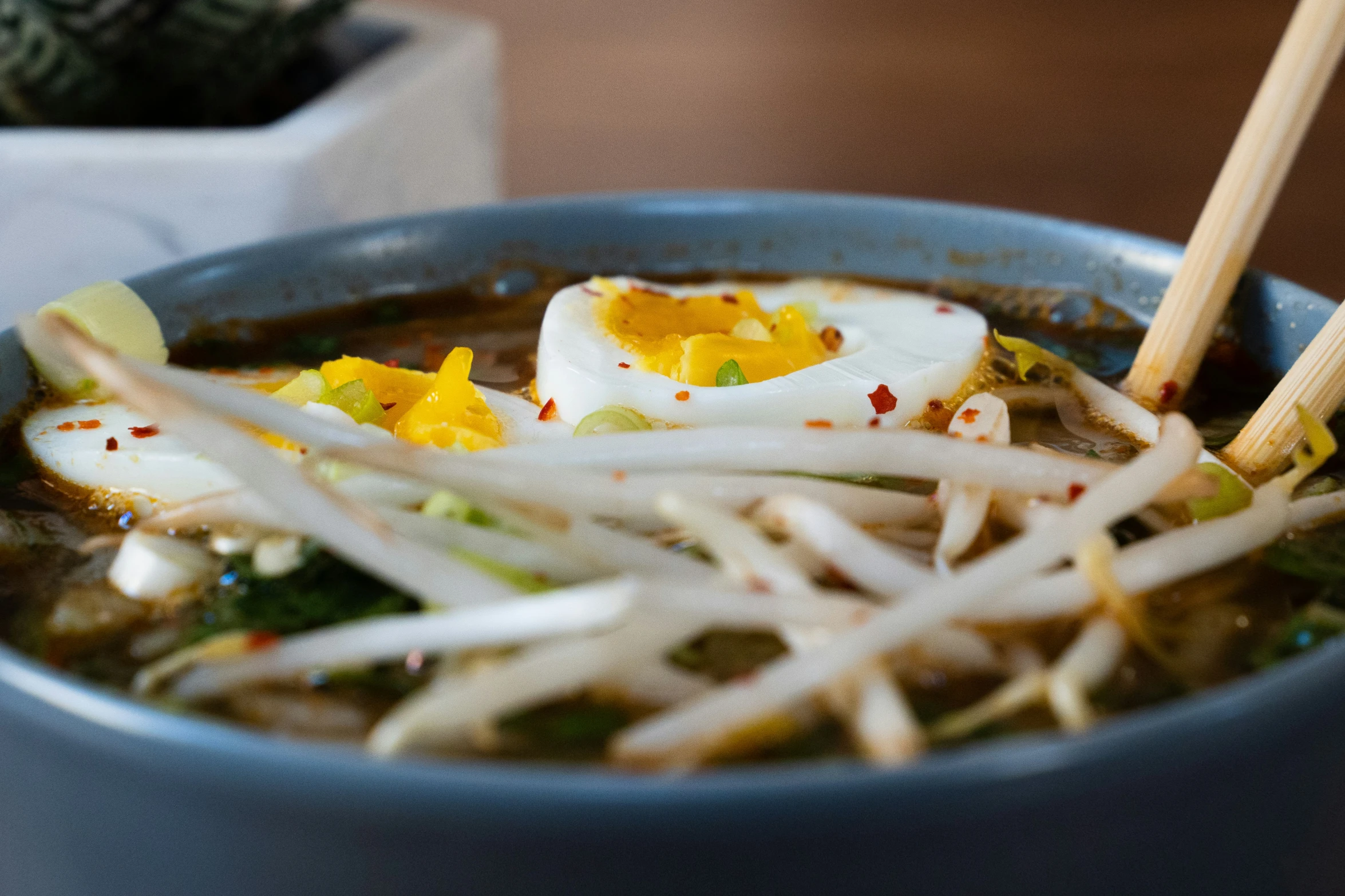 food in a bowl with chopsticks on top