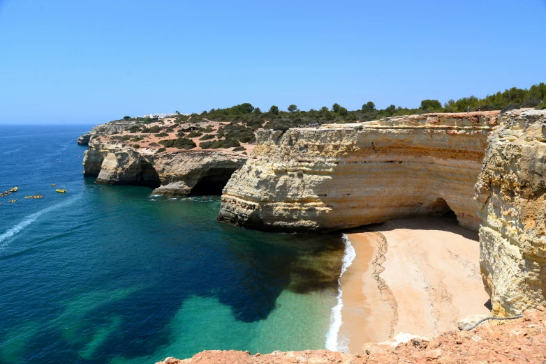 there are cliffs next to the beach with white sand