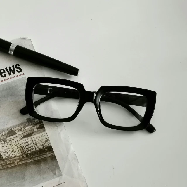 a pair of glasses with news paper in the background