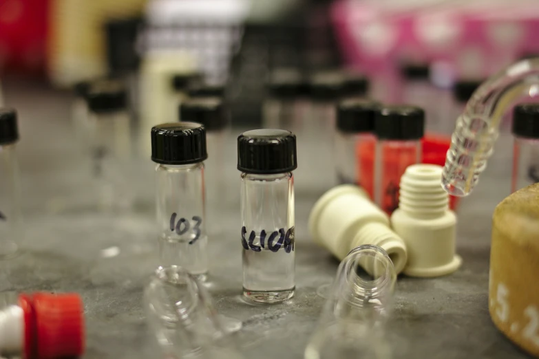 some little glass bottles with black caps are lined up