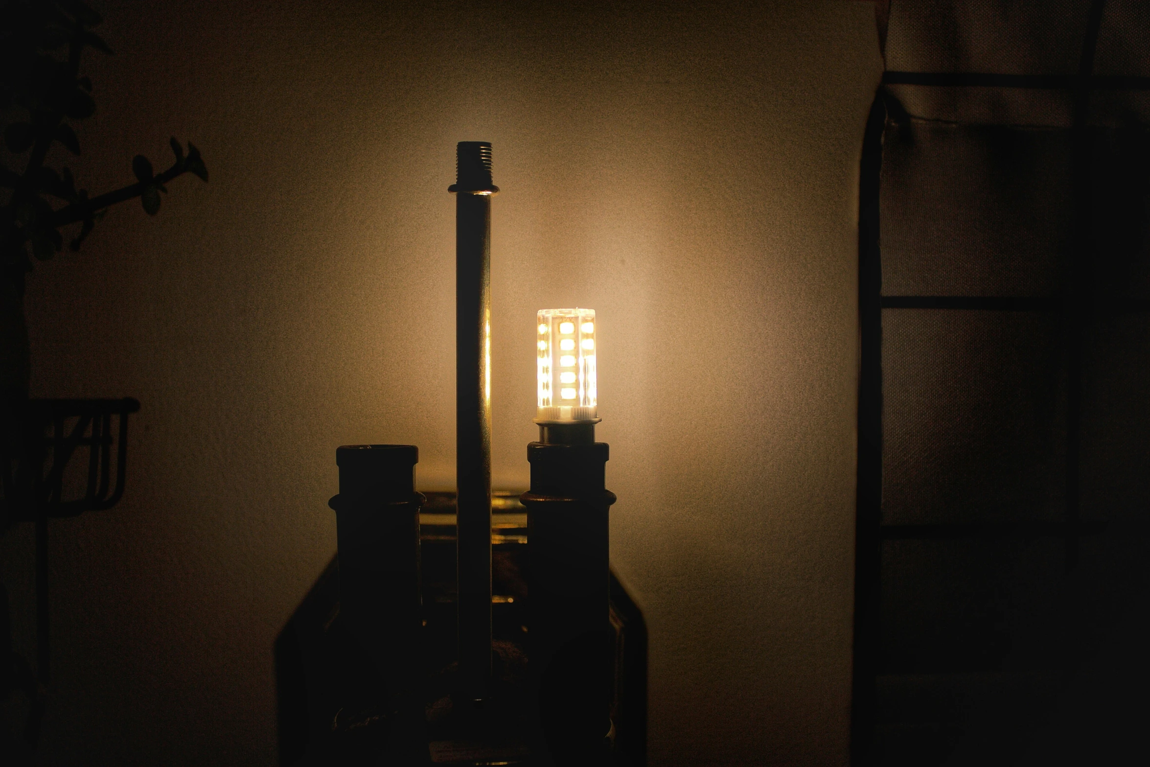 a bottle is on a small table in the dark