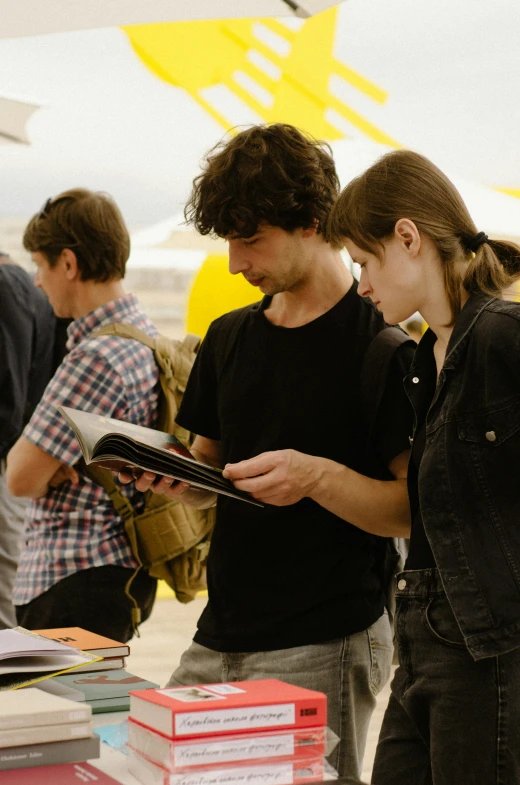 people are looking at books on a table