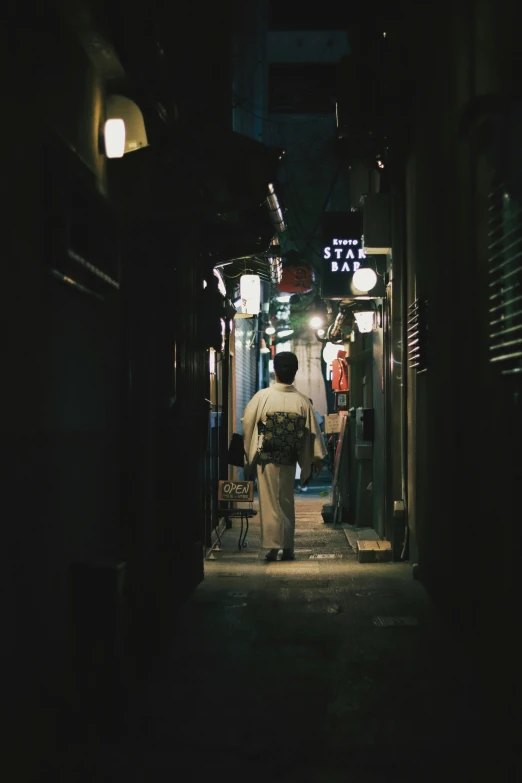 a man is walking down the dark alley way