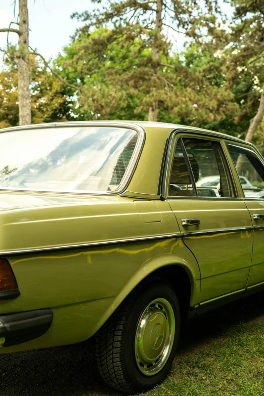 a old model green car is parked in a field