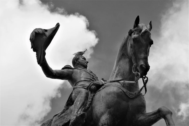 a black and white image of a statue with a man on it